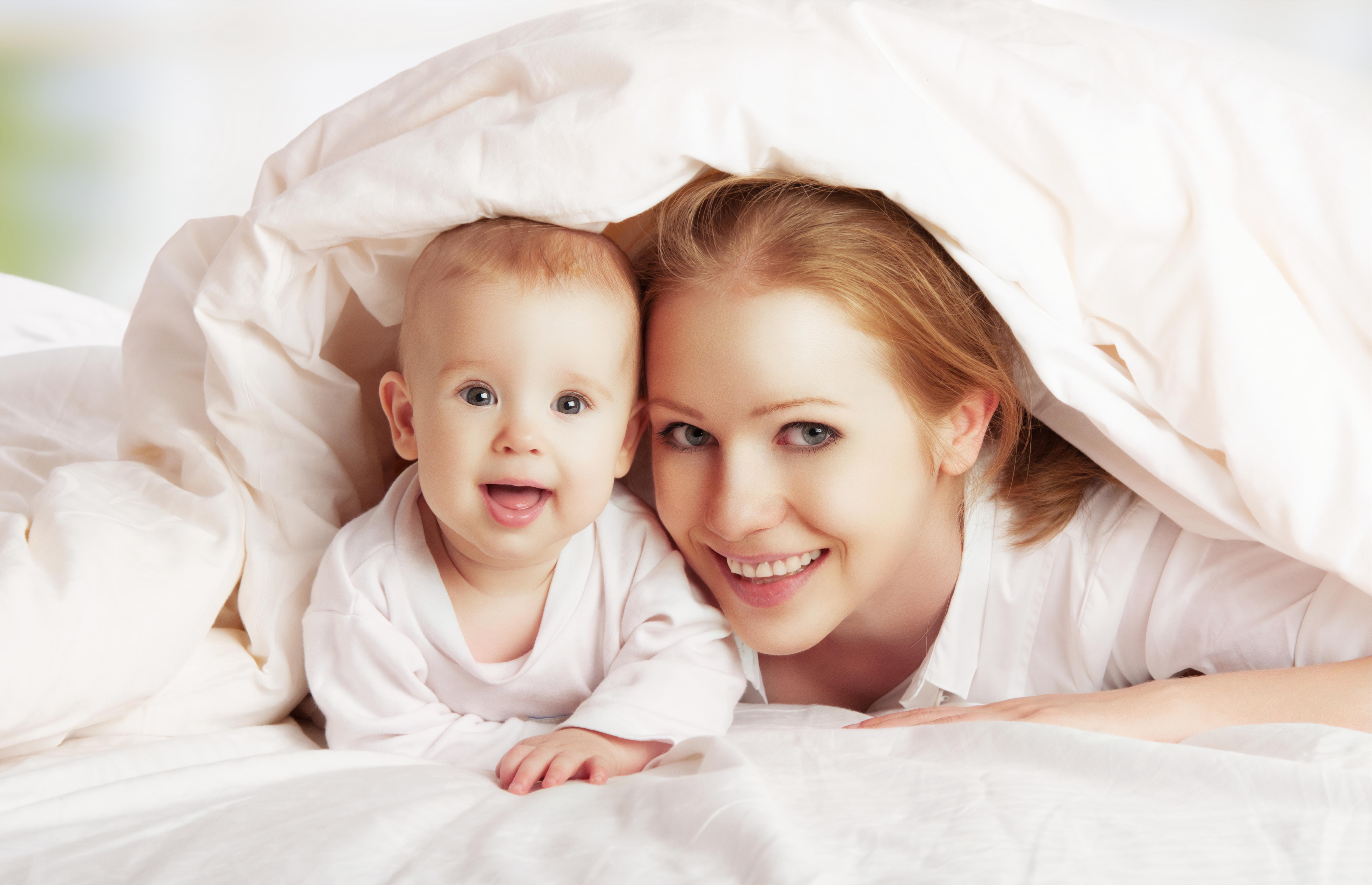 Depositphotos_22443941_ds_MOTHER_BABY_BED_under_cover_smiling.jpg